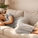 식후 바로 눕는 습관으로 햇살 드는 거실 소파에 편안하게 누워 휴식을 취하는 사람의 모습