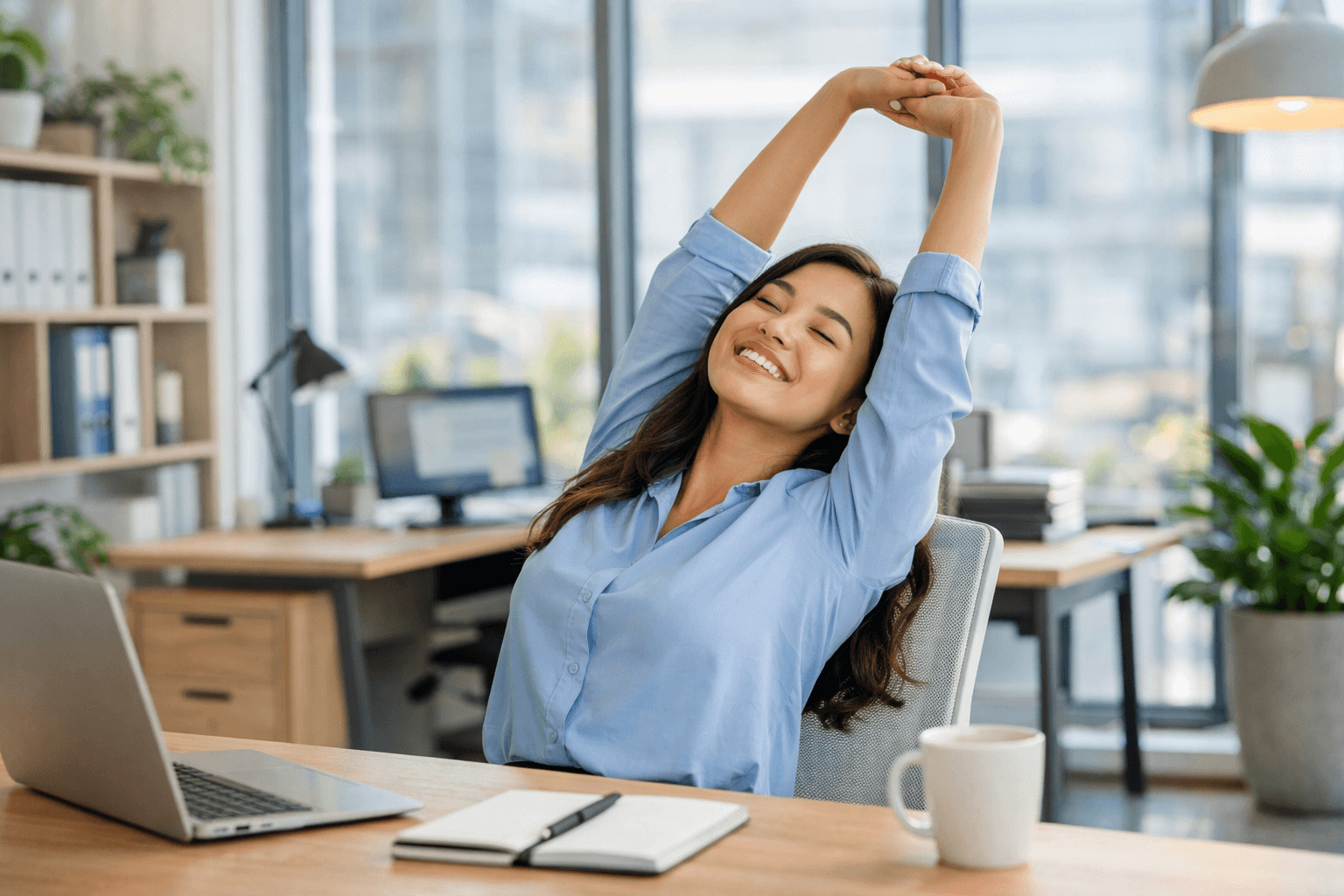 밝은 사무실에서 직원이 자리에서 일어나 스트레칭을 하며 허리 통증 예방을 위한 움직임을 실천하는 모습