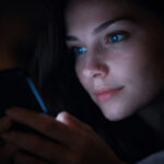 밤에 스마트폰을 보는 사람의 얼굴에 푸른 화면 빛이 비치는 모습, 스마트폰 시력 저하와 눈 피로를 설명