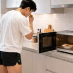 전자레인지 냄새를 확인하는 한국 청년의 주방 생활 장면